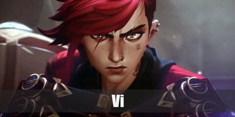 Vi wears a white top, red cropped jacket, striped pants, and mismatched boots. She also has red hair and tattoo on her face.