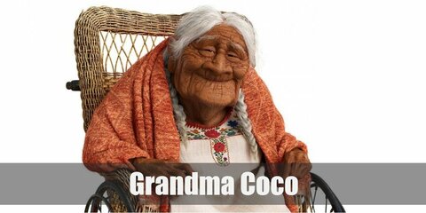Mama Coco’s costume is a white embroidered dress, white socks, pink fluffy slippers, and an orange shawl. Mama Coco is also known for her all-white hair styled in twin braids.