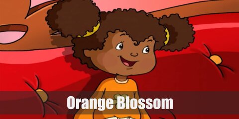 Orange Blossom's costume has an orange sweater, pants, and brown shoes. Her hair is work in side parts and she tops it off with a hat.