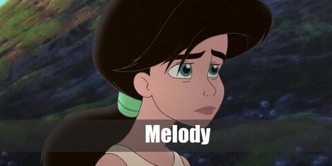 Melody’s costume can be recreated with a khaki sleeveless top, necklace, and red mermaid-style skirt. She also has long dark hair in a ponytail.