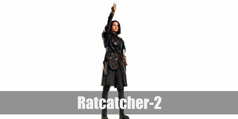  Ratcatcher 2’s costume is a black trench coat, black pants, brown fingerless gloves, and a signature gas mask.