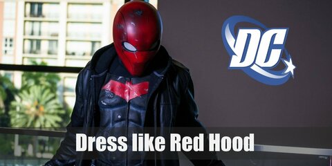 Red Hood's costume is a black outfit with a red band on the chest, a brown jacket, gray boots, and a red full-head mask.