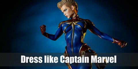 Captain Marvel's outfit is a full-body uniform with red and blue pattern that has the Kree symbol on the chest. She also wears red gloves, red boots, and a red belt.