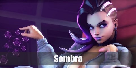 Sombra's costume can be recreated with a purple long-sleeved top, vest, and fingerless gloves. You may also cop black leggings, purple boots, and purple wig. Carry a toy gun, too
