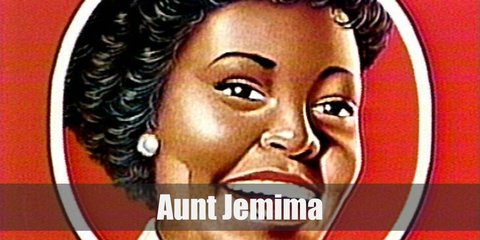 Aunt Jemima wears a red plaid dress, a yellow plaid head scarf, a tied white neck scarf, a white apron, white socks, and black shoes.