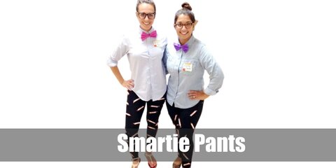  Smartie Pants’s costume is  a long-sleeved button down shirt, black pants with Smarties candy rolls attached all over, flat red walking shoes, a hot pink bow tie, and square-frame eyeglasses.