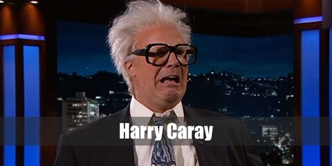 Harry Caray's costume features a white wig with dark-rimmed glasses. He wears a white shirt with necktie under his jacket, too. 