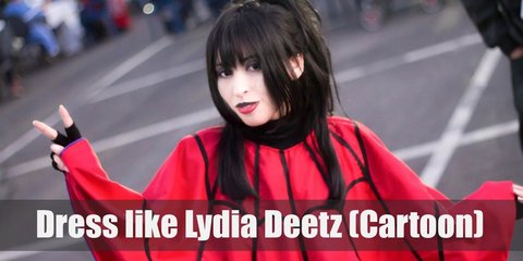 Lydia Deetz wears a red spider web poncho, black boots, gloves, black wig, purple scrunchie, and black and red choker.