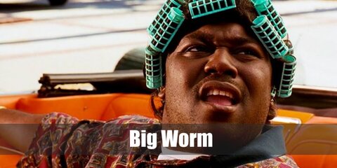  Big Worm’s costume is a printed polo shirt with a collar, long black shorts, classic white casual sneakers, plastic green hair rollers, a wide gold chain wrist bracelet, and gold stud earrings.