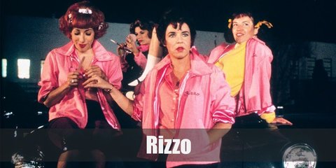 Rizzo is the leader of the Pink Ladies. Rizzo’s costume is a black top, a black pencil skirt, a black belt, and red heels.