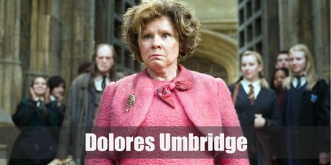 Profesor Dolores Umbridge’s costume is a hot pink dress underneath a light pink knit cardigan, a kitten brooch, and hot pink heels. 