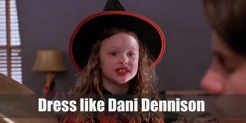  Dani dresses up as a witch for Halloween, which is very timely since her family just moved to Salem. She wears a black turtleneck long-sleeved top, black skirt, red poncho, and a pointed witch’s hat.  