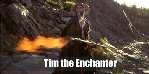  Tim the Enchanter’s costume is a black hooded robe, medieval lace-up boots, a ram horn hat, a gray beard and mustache, and a large bone necklace.