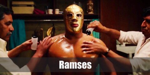  Ramses’s costume is a gold wrestling mask, gold leggings, gold boots, gold wrist cuffs, and a gold cape.