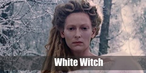  White Witch’s costume is a medieval white overdress gown, T-strap silver glitter heel shoes, an icicle crystal tiara, and a white witch cloak.