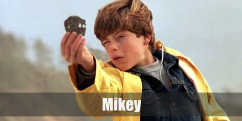 Mikey’s costume is a grey shirt, a denim button-down jacket, a yellow raincoat, and denim jeans. Be a born leader like Mikey from the Goonies.