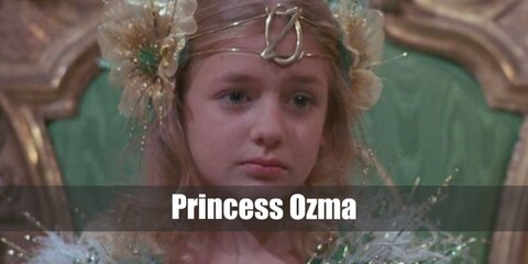  Princess Ozma’s costume is a white flowy dress, and an Oz-themed tiara with red flowers on the side. She also holds a golden Oz-themed scepter.