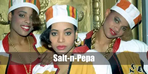 Rock the Salt-n-Pepa costume like Beyonce by wearing an Idol Maker jacket, a red bodysuit, and golden sneakers. Style the look with a Kente hat, a gold chain, and belt bag.