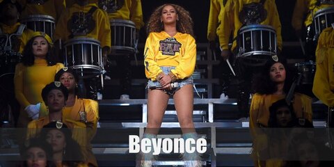  Beyoncé costume is a yellow cropped hoodie, light washed denim shorts, silver leg warmers, white go go boots, fishnet tights, and gold hoop earrings.