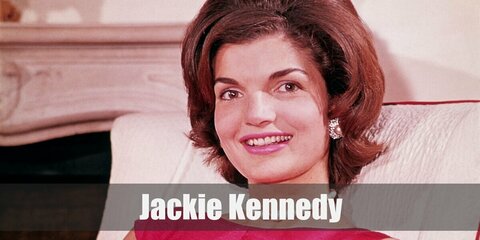 Jackie O's costume consists of a pink blazer and skirt. Wear a black collared shirt under, too. Complete the look with a wig and fascinator.