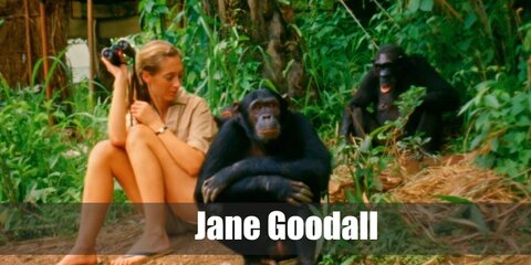 Jane Goodall wears a khaki camouflage top and shorts. She also carries binoculars.