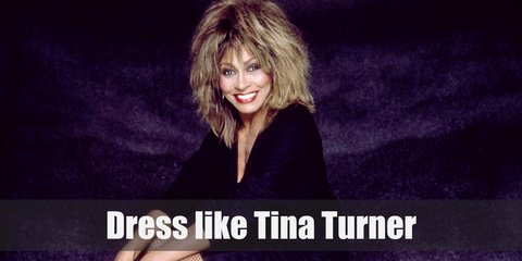Tina Turner's costume includes a gold or nude tassel dress, gold heels, and a soul-inspired wig