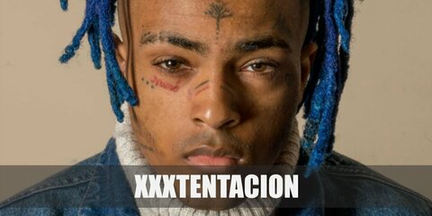 XXXTENTACION's clothes include a white tank top and denim jacket, printed shorts, and high-top sneakers. Recreate his costume with face tattoos and colored dreadlocks.