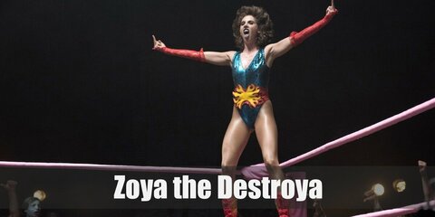 Zoya The Destroya's costume is focused on a red one-shoulder body suit. Style it with a red choker and a red sleeve. Wear a short wig and style the hair into a cool updo. Be sure to add in a black belt with gold buckle as well as a pair of black boots.