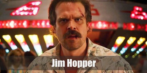 Jim Hopper’s costume is a khaki button-down shirt, a navy blue jacket, khaki pants, brown boots, dark aviator sunglasses, and a brown Mountie hat. Feel safe in Hawkins with the Chief of Police.