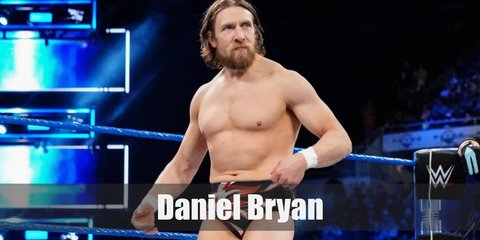 Daniel Bryan wears red-and-black trunks with matching wrestling boots. Wear skintone shirts with this costume. He has long, unkempt hair and facial hair, too.